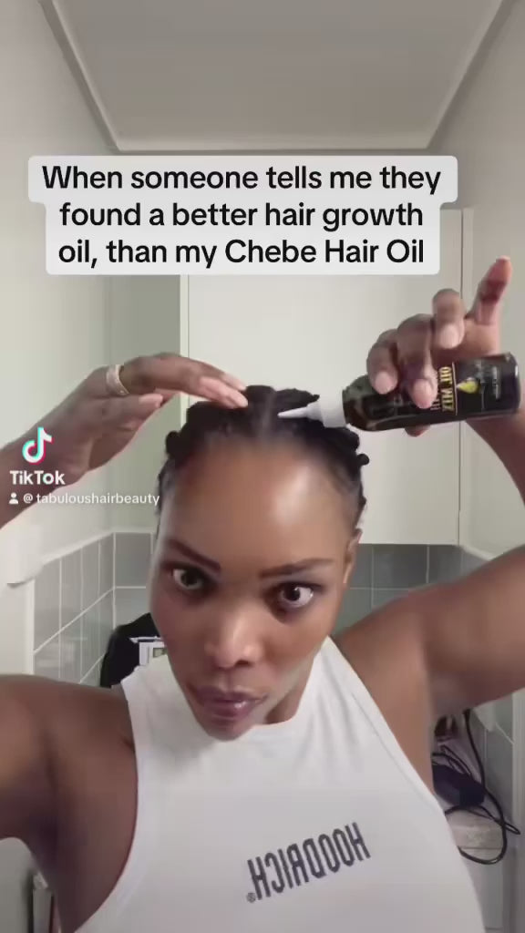 Load video: a woman applying chebe hair growth oil on her hair